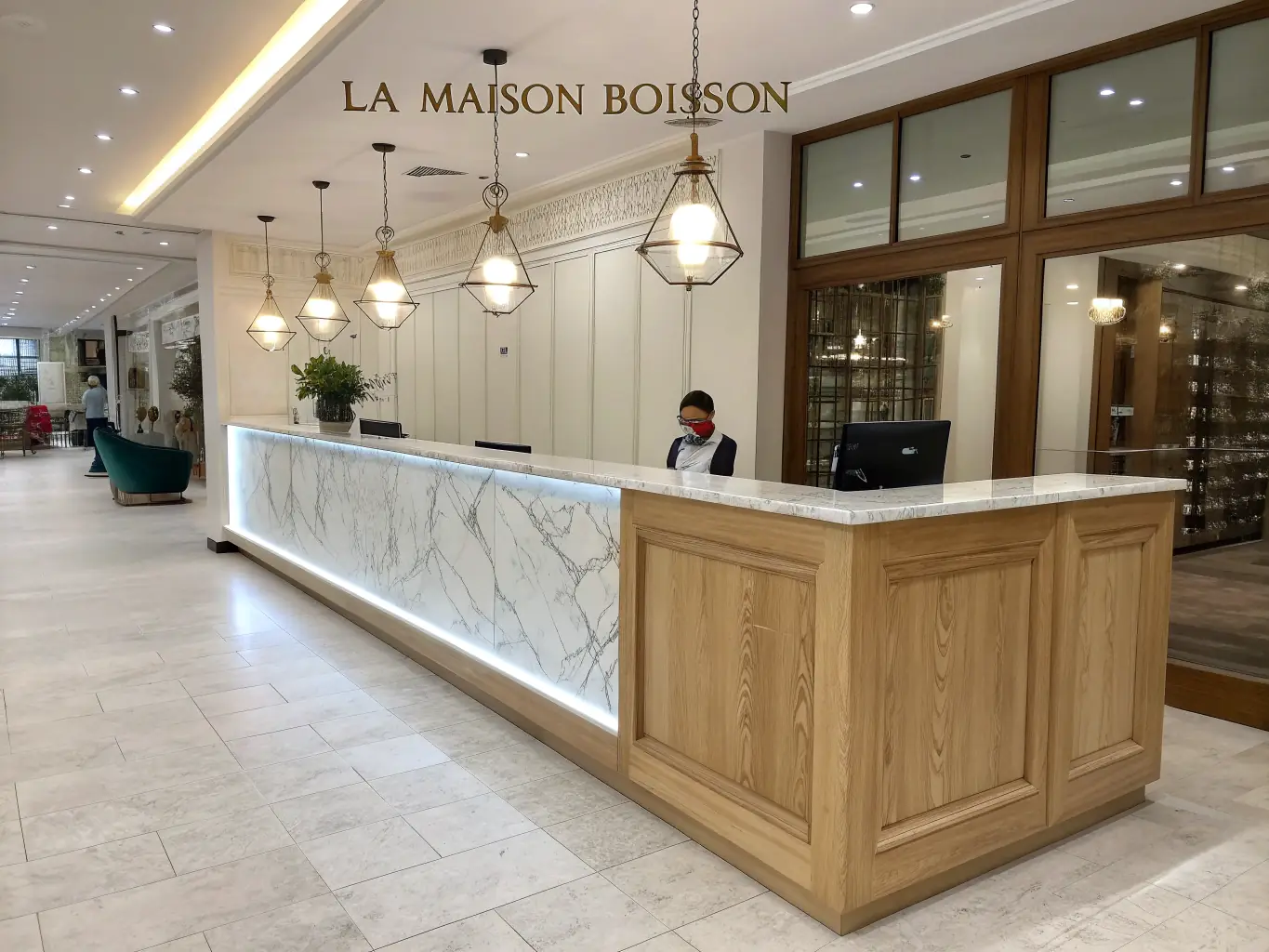 A brightly lit modern office space featuring a custom-designed reception desk made of light wood with the SteelcaseCo logo subtly displayed. The desk is curved and ergonomic, with comfortable seating for visitors.